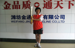 任佳在金通企业文化墙前展示火炬